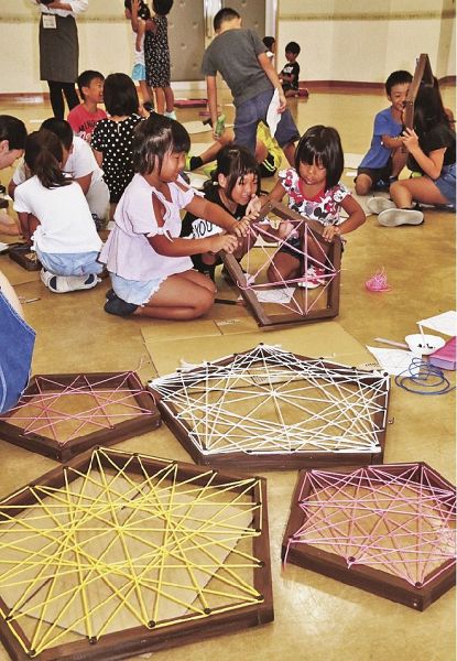 木枠に打ったくぎにひもを掛けていく子どもたち（和歌山県すさみ町周参見で）