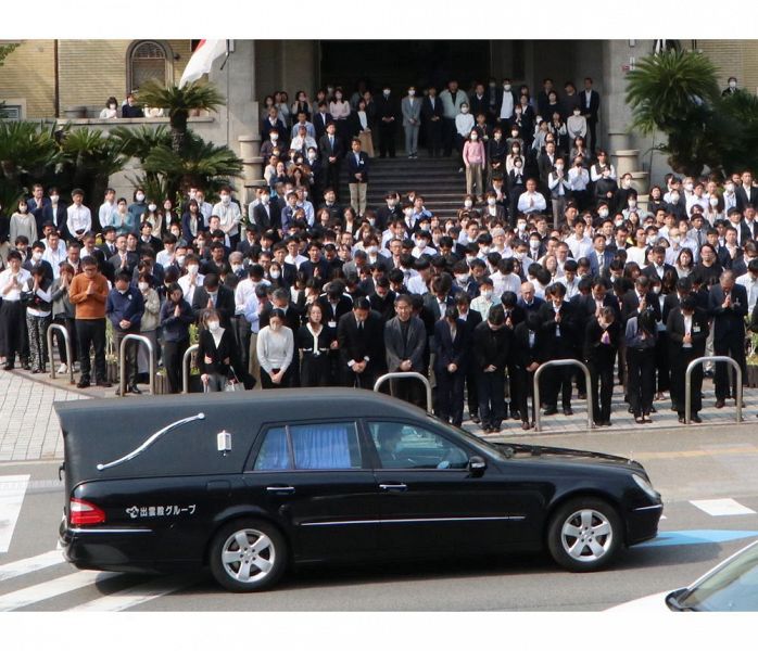 岸本周平知事を乗せた霊柩車に手を合わせる県職員ら（17日、和歌山市の県庁前で）