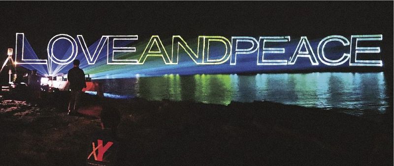 夜の岩壁に照射されたレーザービーム文章（２４日、和歌山県白浜町椿で）