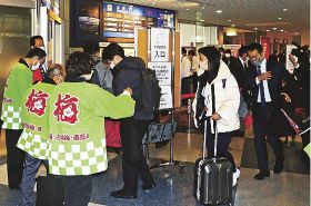 臨時便の搭乗者に梅干しなどを配布する関係者