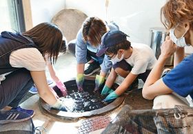 準備した布を工房で染液に漬ける作業（和歌山県田辺市龍神村小家で）